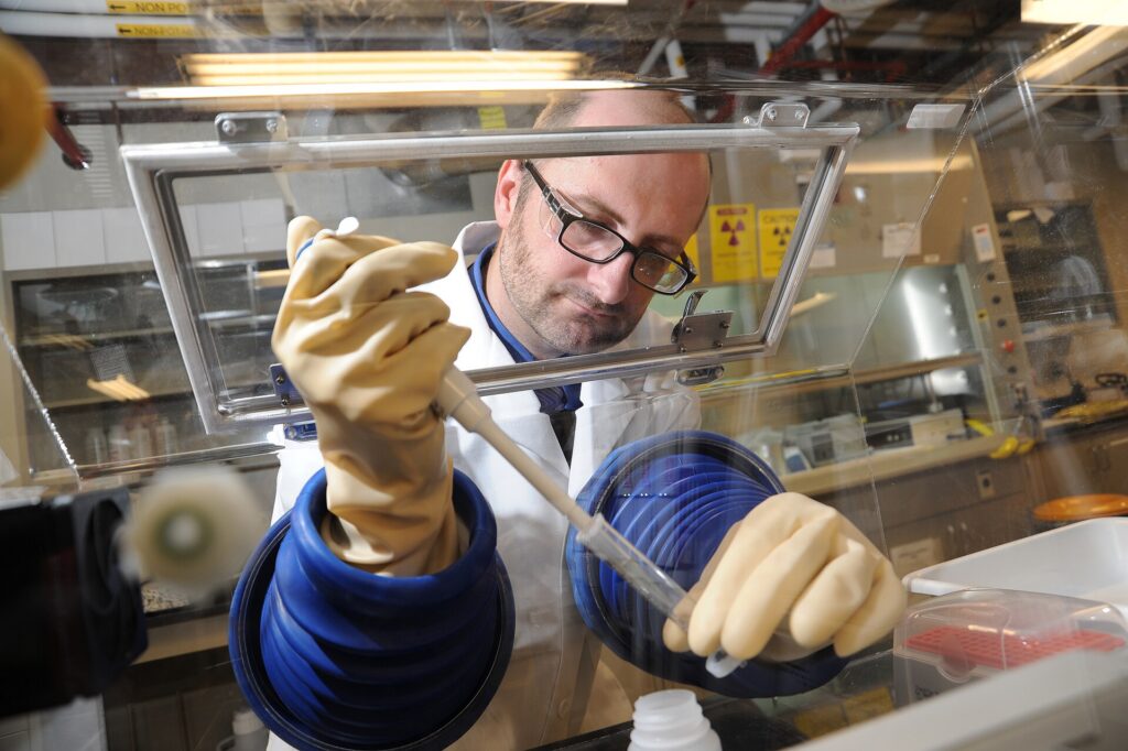 Scientist working at a laboratory glovebox separating complex mixtures